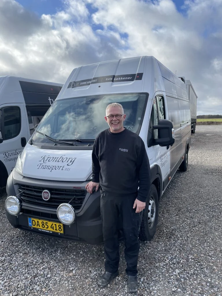 Mand står ved siden af transportbil fra Kronborg Transport.