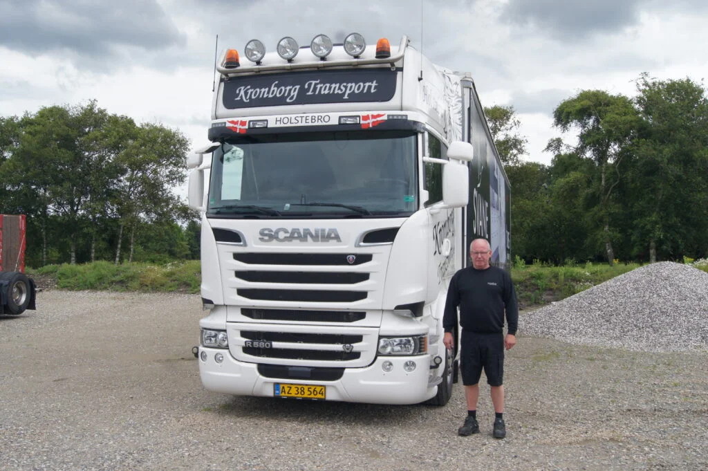 Chauffør foran hvid Scania-lastbil fra Kronborg Transport.