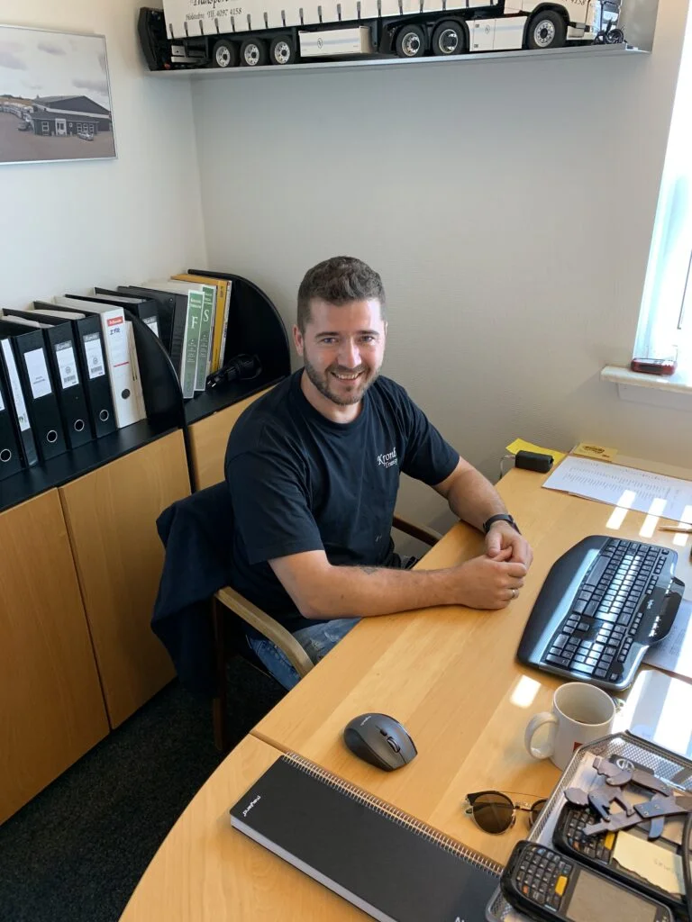 Mand sidder ved skrivebord på kontor