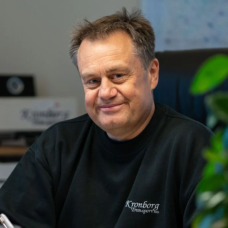 Mand i sort trøje ved skrivebord