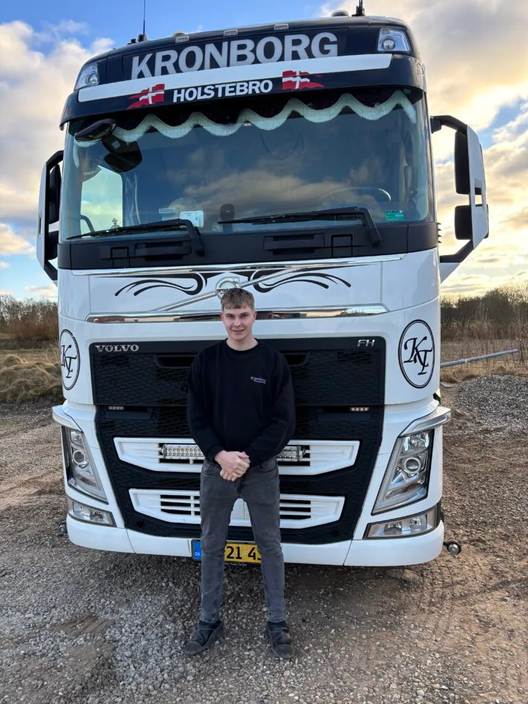 Person foran lastbil på grusvej